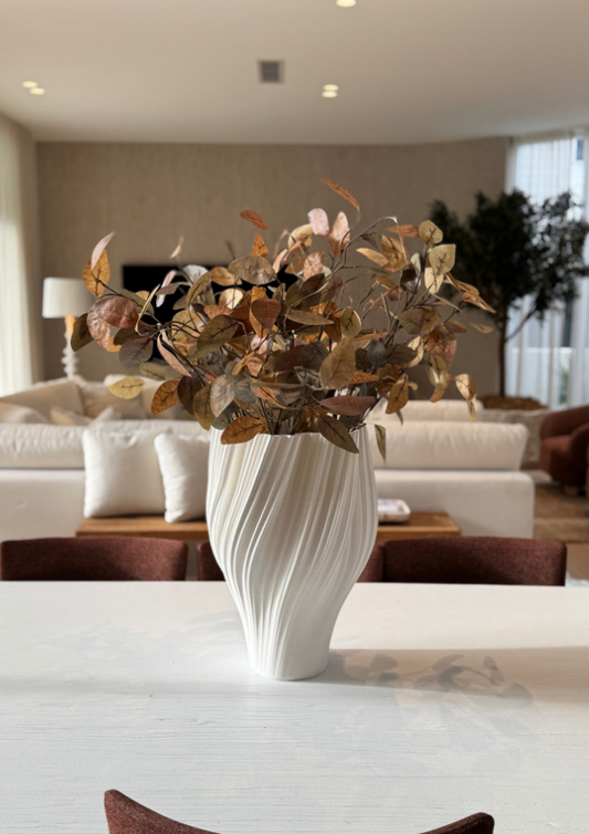 Bungalow Home Interiors Decor styling. Decorative vase with dried leaves on a table in a modern living room.