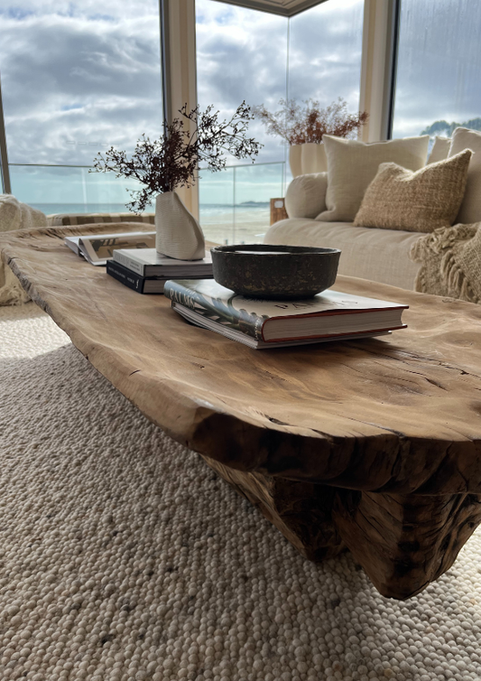 Wooden coffee table with decorative items in a living room with a view of the ocean. Bungalow Interiors Design Studio & Showroom, Runaway Bay, Gold Coast