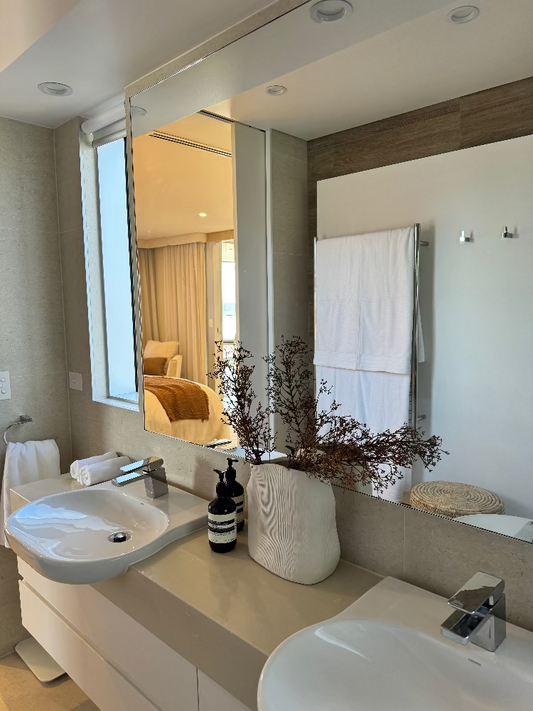 Modern bathroom with double sink vanity, large mirror, and decorative elements. Bungalow Interiors Gold Coast