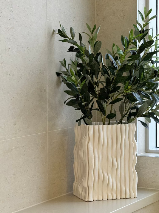 White textured vase with green plant against a neutral wall. Bungalow Interiors Gold Coast