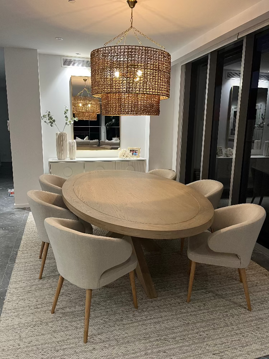 Dining room with a round wooden table and beige chairs, featuring a chandelier. Bungalow Interior Design, Gold Coast