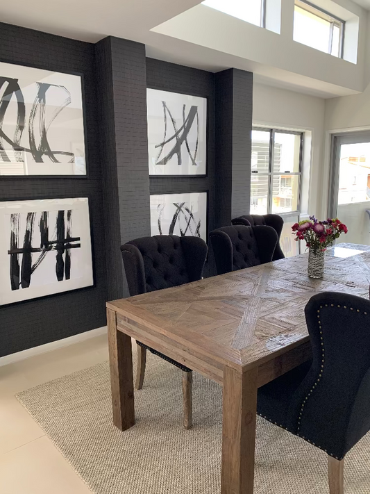 Dining room with wooden table and black chairs against a wall with abstract art. Bungalow Interior Design, Gold Coast