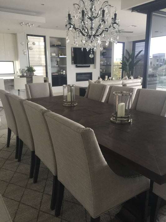 Dining room with a large table and chairs, chandelier, and large windows. Bungalow Interior Design, Gold Coast