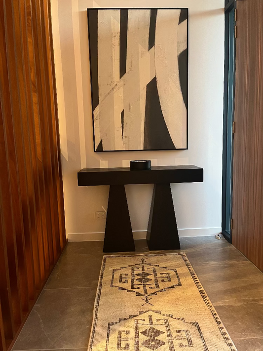 Modern interior with a black console table and abstract art on a white wall. Bungalow Home Interiors Design Studio
