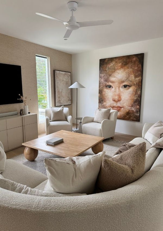 Modern living room with a round sofa, coffee table, and wall art.