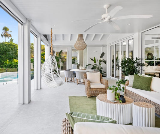 Modern living room with white furniture, green decor, and large windows. Home styling Bungalow Interiors Gold Coast