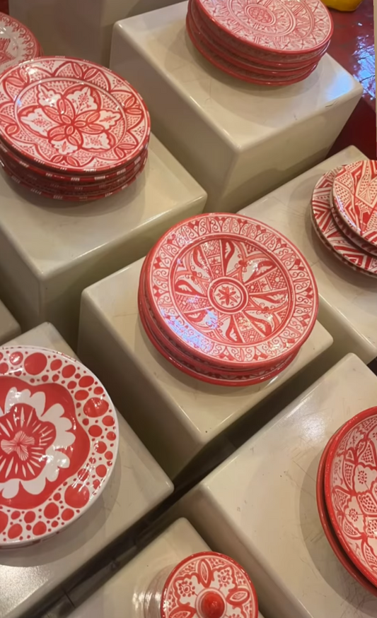Red decorative plates with intricate patterns on a white surface