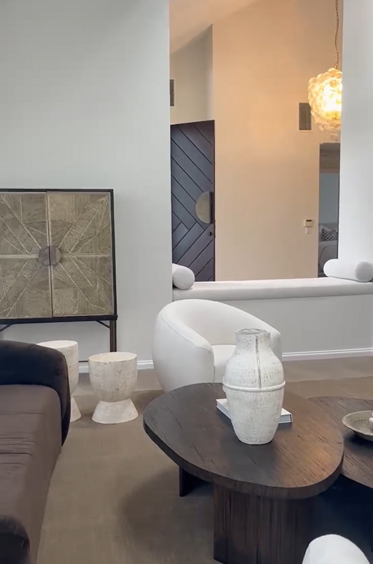 Modern living room with a white sofa, wooden coffee table, and decorative items.