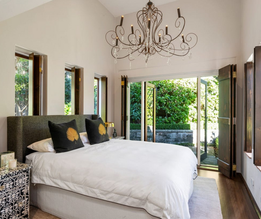 Modern bedroom with a chandelier, bed, and large windows. Bungalow Home Interiors Design & Styling, Gold Coast