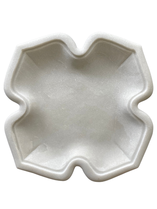 A white marble decorative tray with a star-shaped design