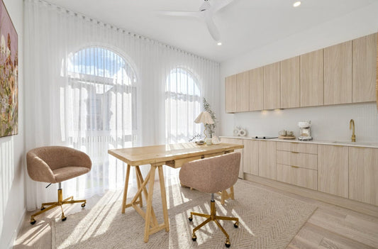Modern kitchen with wooden table and chairs, light wood cabinets, and a window with white curtains.  Bungalow Interiors Gold Coast, coastal interior design styling