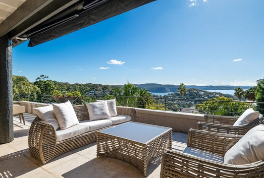Outdoor patio with wicker furniture and a scenic view of a body of water home styling by Bungalow Interiors