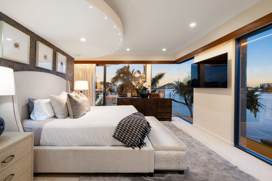 Modern bedroom with a large bed, nightstands, and a television in a room with large windows.  Bungalow Interiors, home styling, Gold Coast